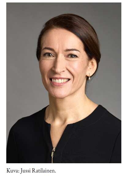 Kuva, jossa tasavallan presdentin puoliso Suzanne innes-Stubbin kasvot ja ylävartalo. Hymyilevät kasvot, ruskeat hiukset taakse sidottuna Musta avonainen paita.